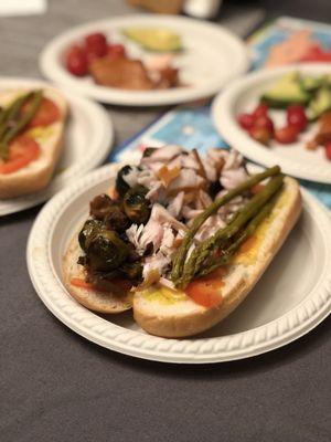 Red Onion, Smoked White Fish, Butterkase, Beefsteak Tomato, Mama Lil's Asparagini, Fresh Roll, BBQ Eggplant Salad. Background: Smoked Salmon