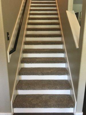 The completed stairwell with new white risers and carpet.