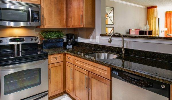 Modern kitchen features stainless steel appliances, granite countertops in select homes