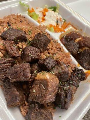 Rice and beans (Waakye/ Ayimolu) with fried beef and a side salad and boiled egg swimming in the best sauce