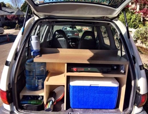 Kitchenette includes a cooler, camp stove, fresh water pump, place setting for 2 and pots & pans