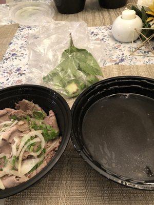 Beef pho - broth in one bowl, meat and noodles in the other and ziplock of basil, jalapeño, small piece of lime and siracha packet.