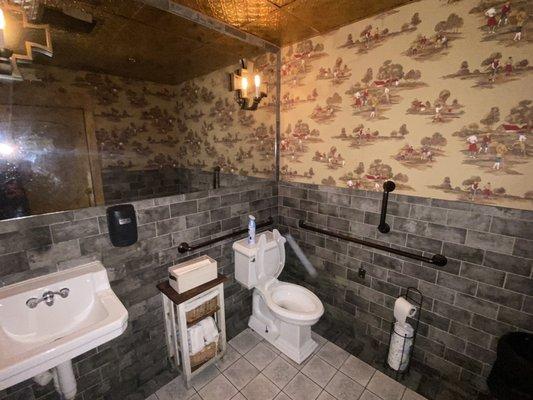 Individual toilets. No gender designations. Golf theme wallpaper.