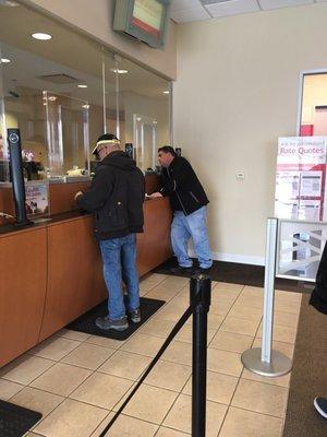 This rude man by the wall was awful towards the teller, but she still serviced him with the courtesy of a statesman!