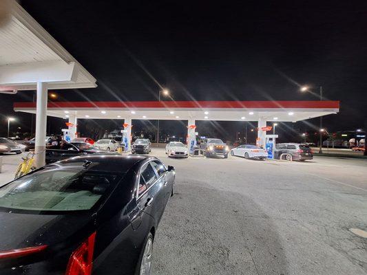 Just the front picture of tanks getting filled and people buying other stuff inside the store at 10:00 p.m.