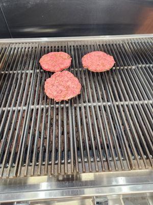 Fresh angus chuck beef patties on grill