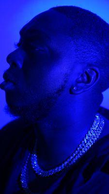 A striking blue-lit profile portrait capturing a moment of introspection and style, perfect for album covers, personal branding, or creative