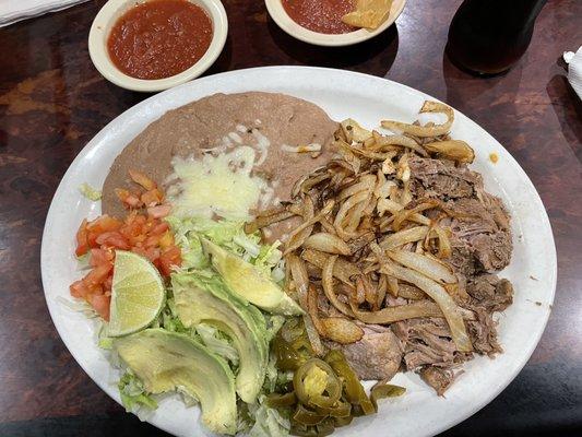 Delicious Carnitas with onions, salad and beans!