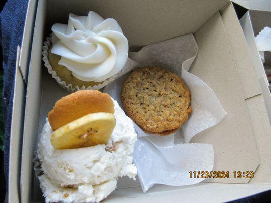 Vanilla cupcake w/ vanilla icing (top left), homemade oatmeal cream pie (center), banana pudding cupcake topped w/ dry banana slice & cookie