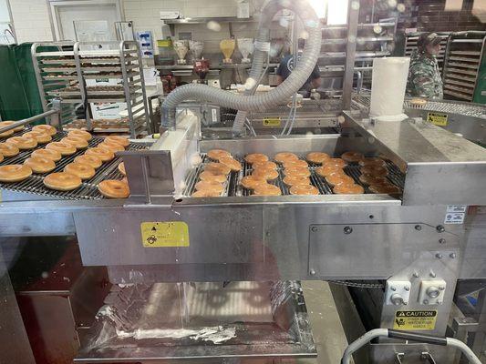 Glazed donuts being freshly made