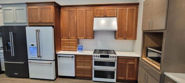 kitchen showroom with appliances on display and wooden cabinetry