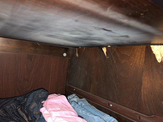 this is the inside of a dresser, can see the damages caused by where the crew picked it up by the top pice of wood