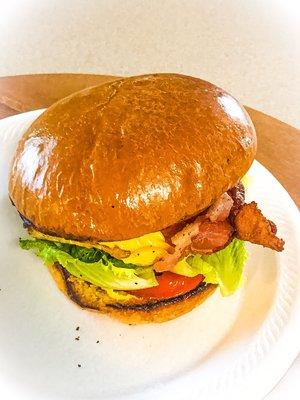 Ground beef patty topped with 'messy' cheese, pickles, onions, lettuce, and tomatoes served on grilled brioche bun. Served with fries.