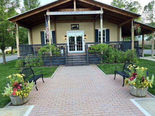 Front of the hotel with nice landscaping and plenty of outdoor deck and porch seating.