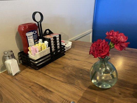 Table condiments and flower in vase