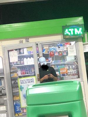 Employee smoking at a gas station.