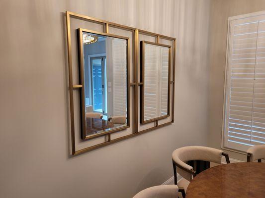 2 Decorative designer Mirrors mounted side by side on painted drywall in formal dining room.