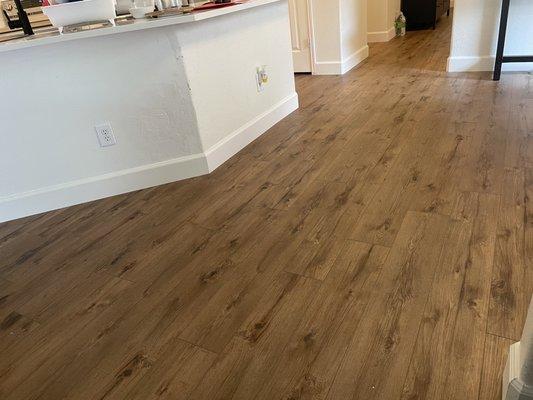 After picture of new waterproof vinyl plank floor and upgraded baseboards. Please ignore any background messes.