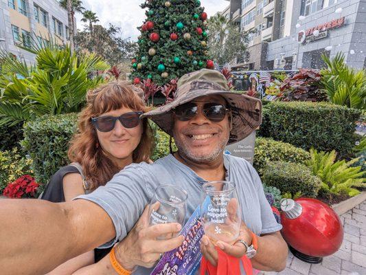 Sipping joy at SoDo's wine stroll, this duo embodies the holiday cheer amidst Orlando's festive glow. #WineLovers #HolidaySpirit