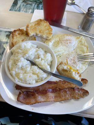 Breakfast 2 eggs over easy, bacon, grits and a grilled biscuit! All served piping hot!