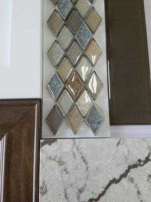 Combo pic of backsplash tile, inlay, quartz, and cabinets