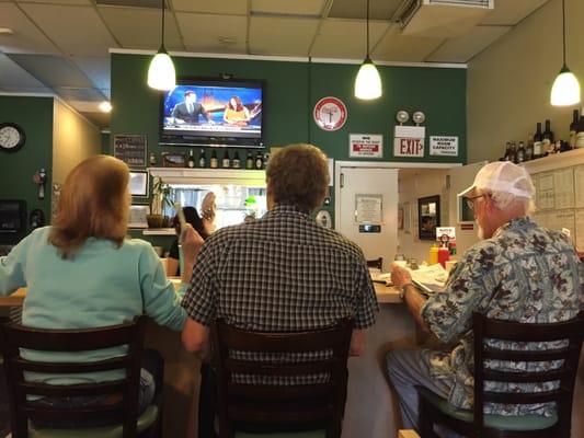 Lita's husband (center) sitting with customers at the lunch counter.