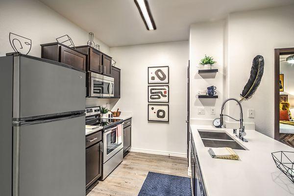 Modern kitchen finishes including quartz countertops, designer cabinetry, gooseneck faucet and stainless steel appliances.