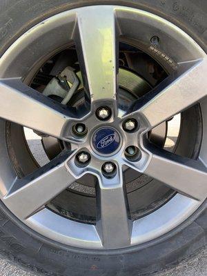 Picture showing missing lug nuts and damage to rim of patched tire.  Remaining lug nuts are rounded off or close to it.