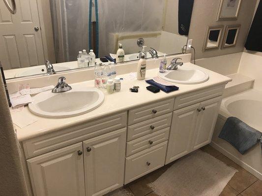 Before photo of vanity, sinks, mirror, and lighting.