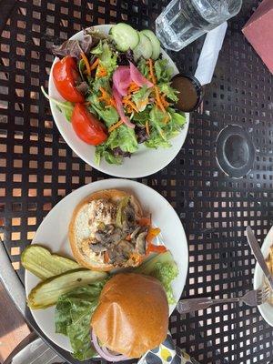 This is the grilled chicken burger with sautéed mushrooms, sautéed bell peppers, and avocado with a side salad.