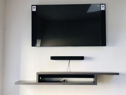 Clean wall with a beautiful entertainment shelf with an awesome 65" TV.