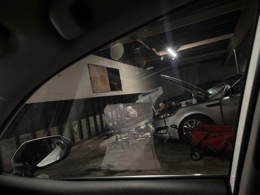 Messy car full of trash parked inside the gated lot