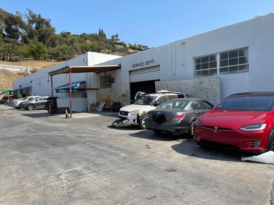 Imax Auto Body Shop Inc parking lot and entrance from back building.