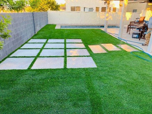 Beautiful backyard with Artificial Turf and large flat steppingstones.