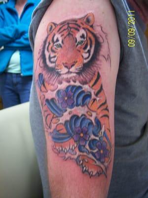 This tiger is covering up an old tattoo.Tattoo by Gale