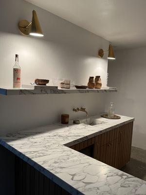 Custom bar installation with solid rift cut white oak.  Wood slats and floating stone shelf.