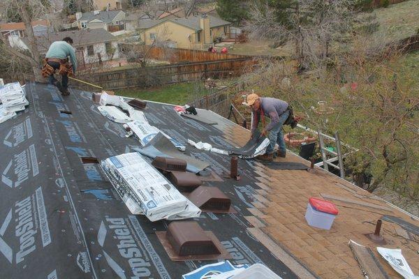 Roofing crew replacing a storm damaged roof in Denver, CO