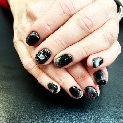 Gel polish manicure with foil nail art and cat eye effect.