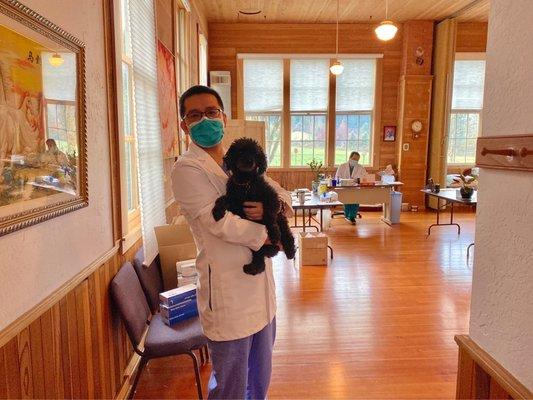 Acupuncturist Leo Zhu and clinic dog James. Acupuncturist Benson Huang at the desk.