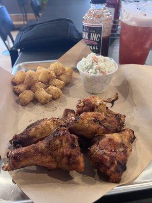 Smoked Bone-in Wings tossed in their dry rub, tots and their slaw. Rum Runner Cocktail in the background.