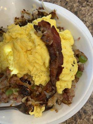 Corned beef hashbrown skillet showing the strip of pork bacon that was buried inside