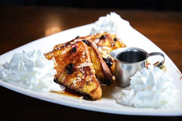 Teton French Toast - Two thick slices of brioche topped with local huckleberries, whipped cream, toasted almonds, and powdered sugar.