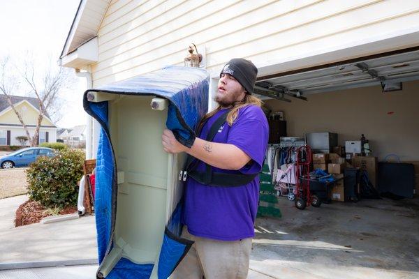 A Relocation Specialist carrying a small dresser!