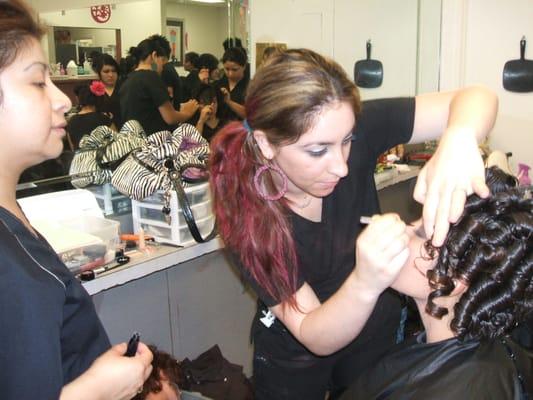 A student helps the Quince Girl get ready by applying smokey eye makeup, while the licensed instructor oversees her work.