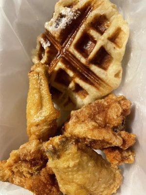 Plain fries wings with sauce on the side and A waffle.