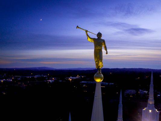 Angel Moroni playing a song to the crescent moon.