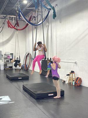 Instructor dressed as Anne Wheeler with child on trapeze.