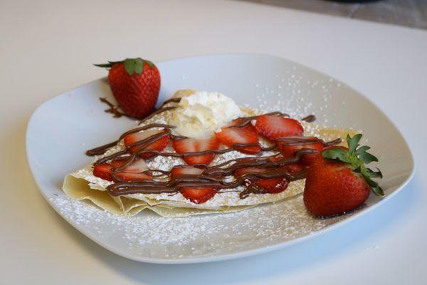 Strawberry Crepe with fresh strawberries, Nutella drizzle, powdered sugar and whipped cream. Also available gluten free.