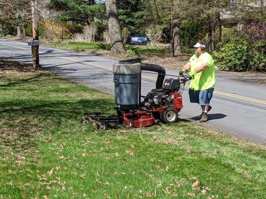 Using a front tine rake to remove leaves from the lawn.