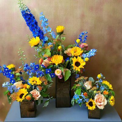 A trio of seasonal floral designs in shades of blue, yellow and peach.